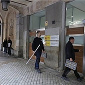Una pareja de técnicos entran en el edificio de Gran Vía en el que, desde este jueves, empezará a funcionar la Audiencia Provincial.