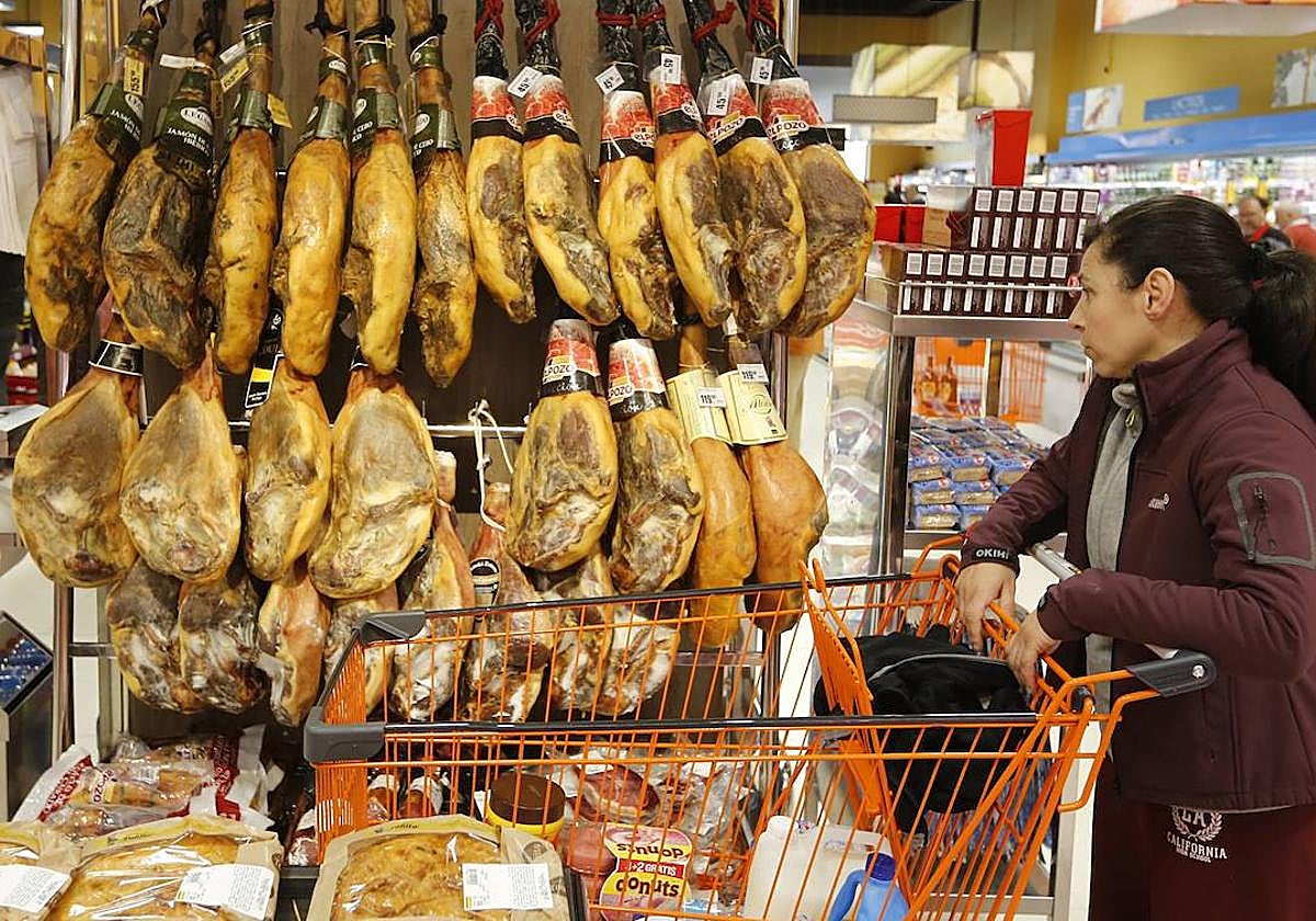 Jamones colgados para la venta en un supermercado.