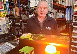 Un vendedor de una tienda de recambios de automóvil coloca algunas luces V16 obligatorias desde el 1 de enero.
