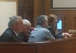 El camionero acusado, de espaldas, entre los abogados defensores.