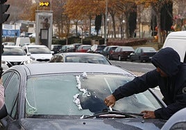 Una persona, quitando el hielo de la luna de su coche.