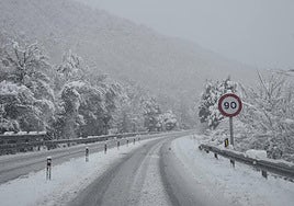 Una señal de prohibido circular a más de 90, en una carretera nevada.