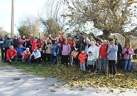 Los asistentes a la jornada, durante una parada junto al potro y el moral que se ubican en el entorno de la iglesia.