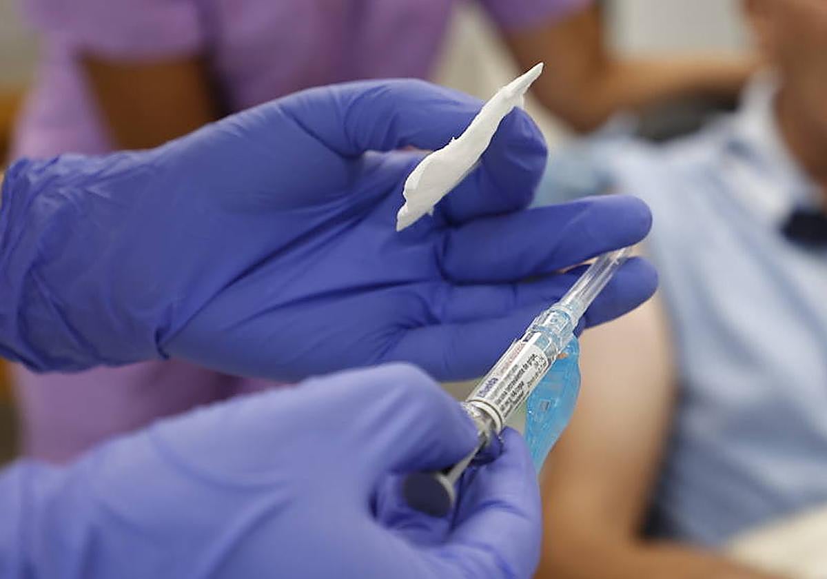 Un médico, a punto de vacunar a una persona mayor.