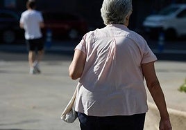 Una mujer pensionista caminando por una calle.