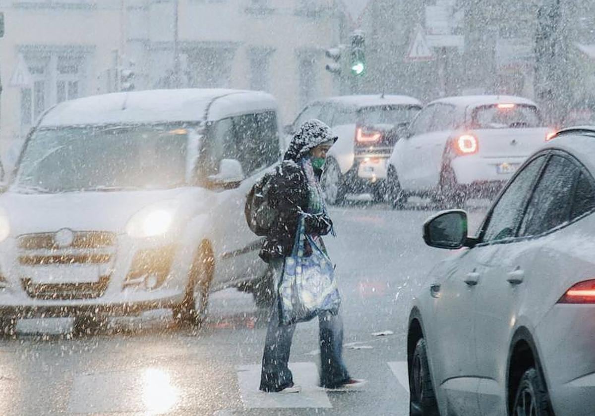 Una joven, caminando bajo la nieve.