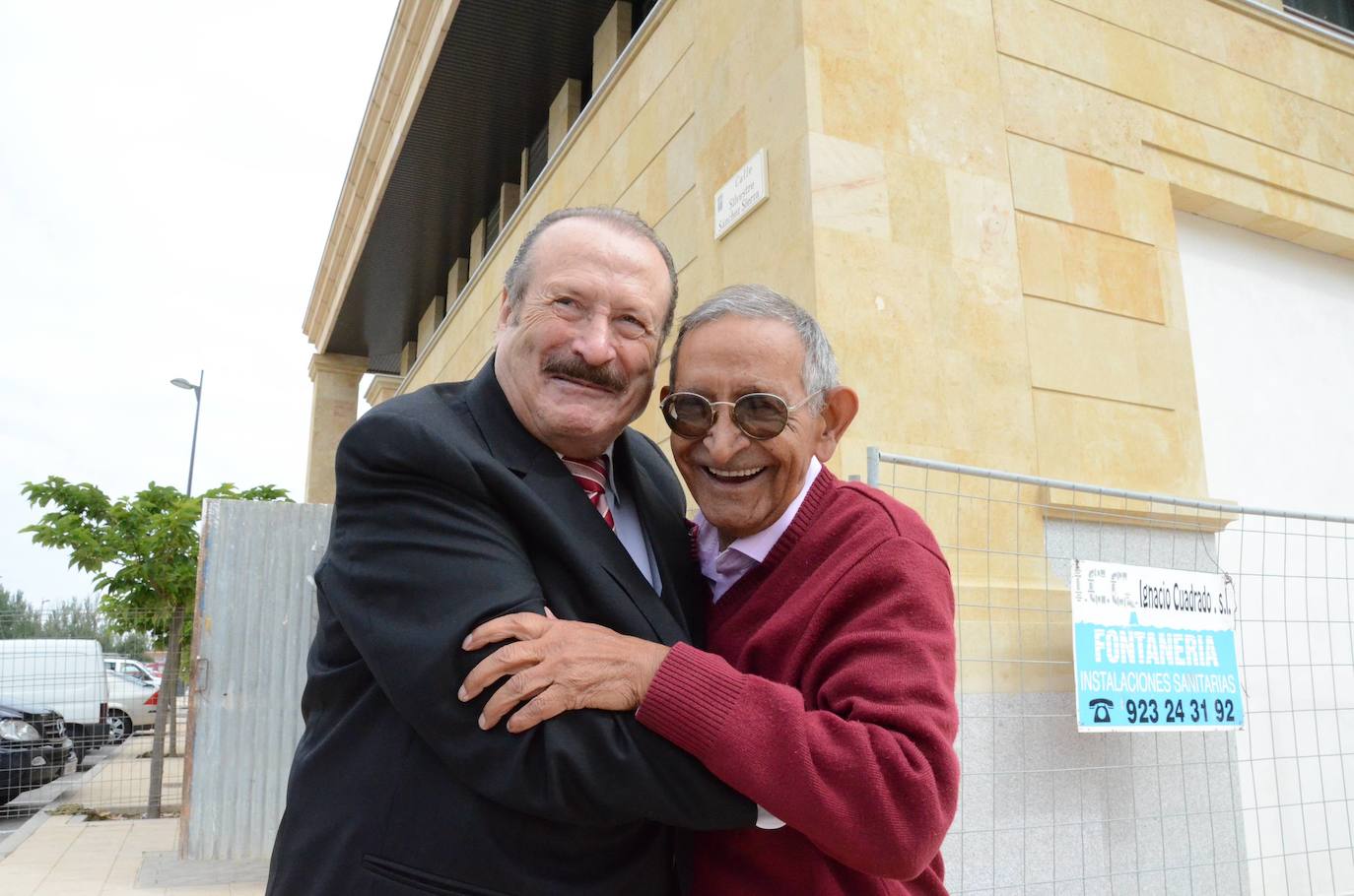 Silvestre Sánchez Sierra y Antonio Romo abrazados junto a su calle.