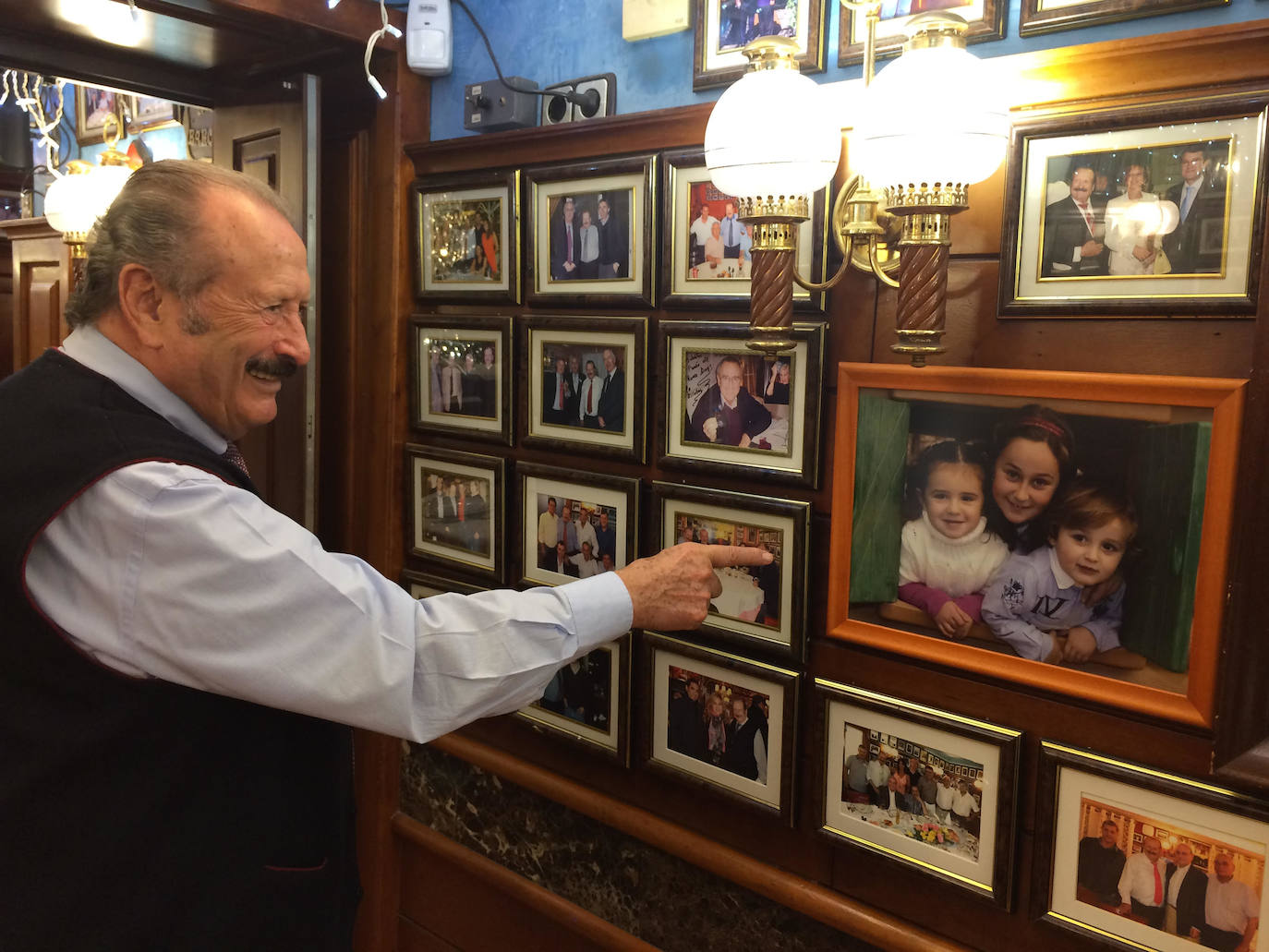 Silvestre Sánchez Sierra junto a la amplia galería de fotos de su restaurante en Barcelona