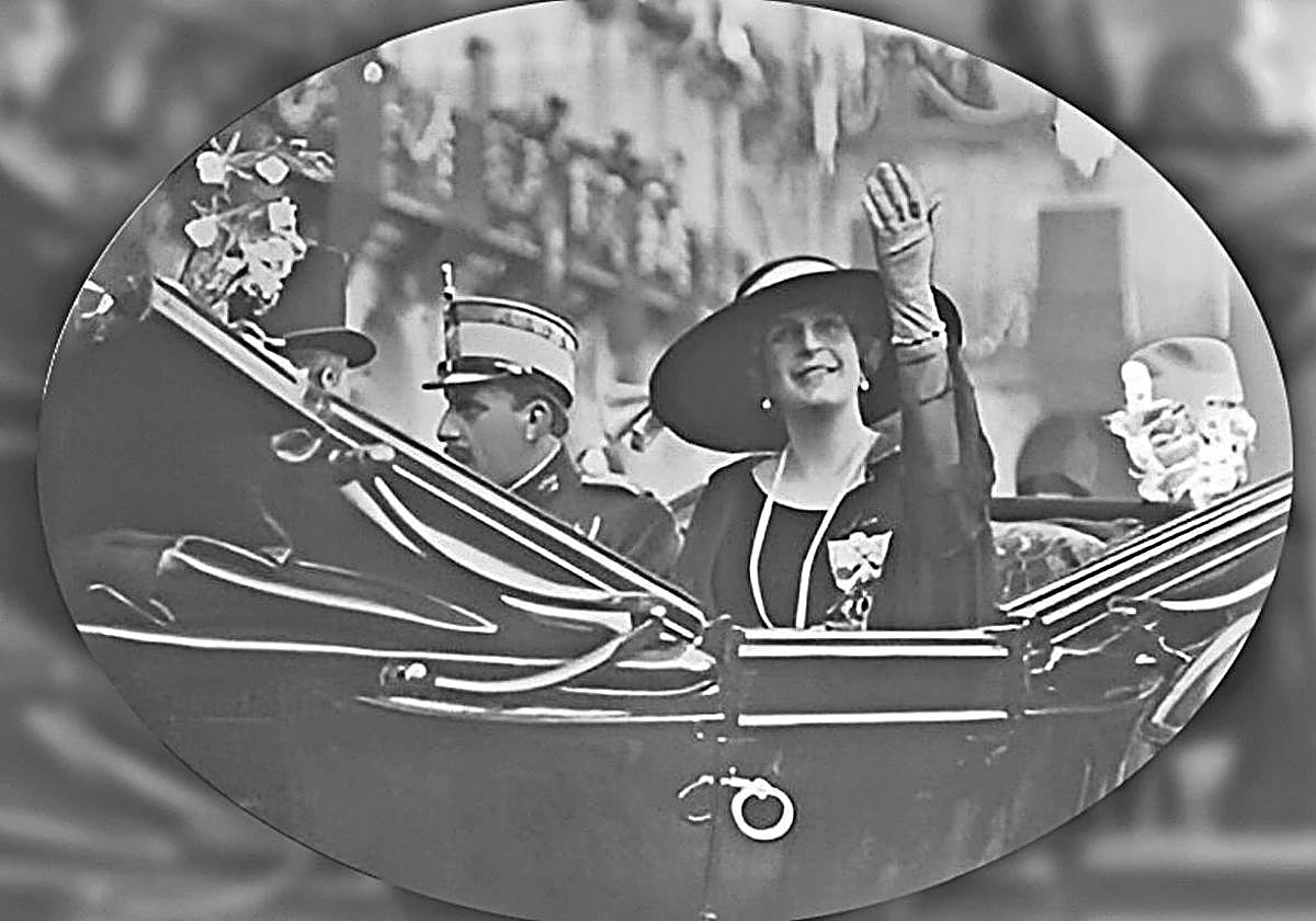 La reina Victoria Eugenia saluda junto al rey desde el coche real en la imagen más conocida de la visita de 1922.La imagen respeta el formato ovalado con que se conserva.