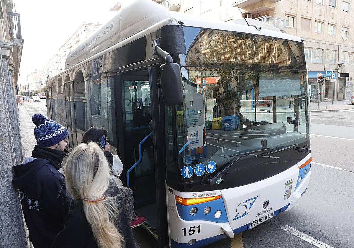 Un usuario consulta el móvil antes de subir al bus urbano de la línea 4 de Puente Ladrillo en la parada de la Gran Vía.