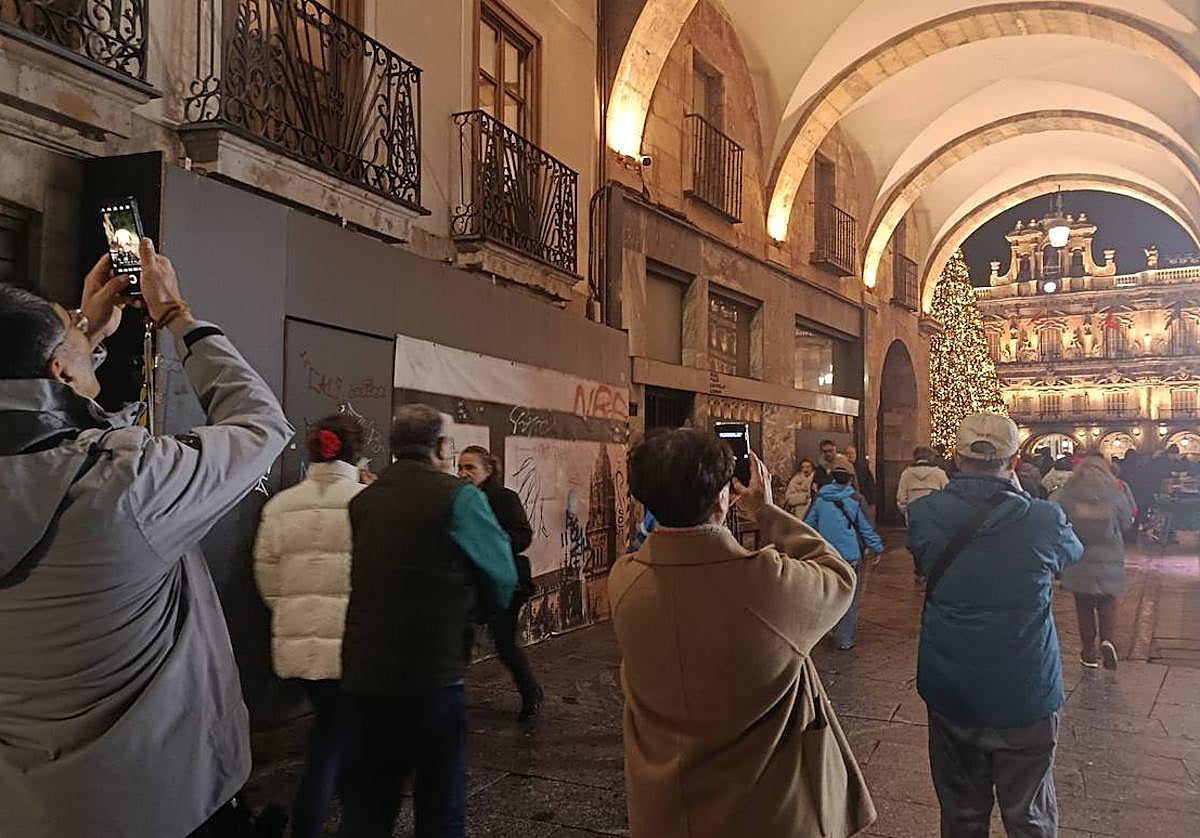 Un grupo de coreanos fotografían el árbol y la Plaza desde un arco.