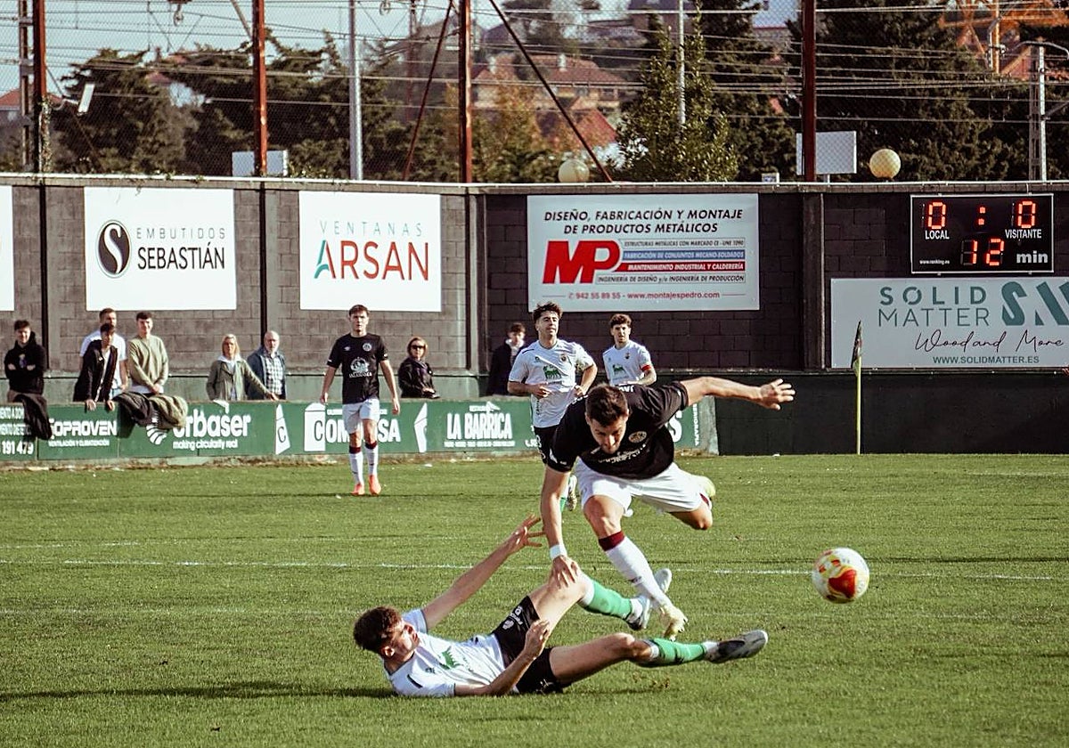 Javi Delgado cae al suelo después de ser agarrado por un zaguero local cuando ya encaraba la portería del Rayo Cantabria.