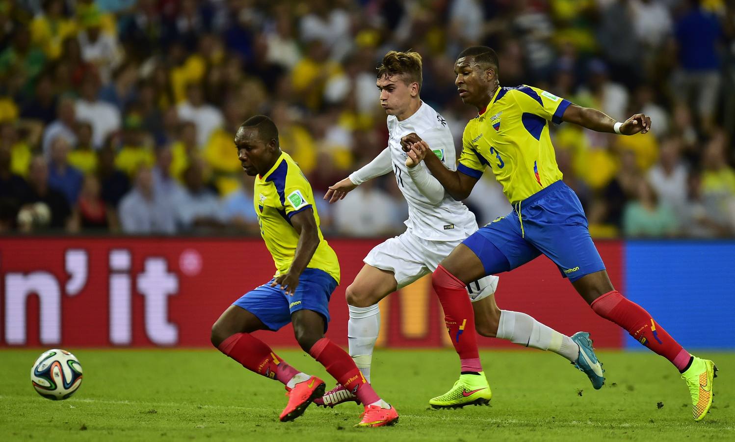 Griezmann intenta marcharse de dos jugadores ecuatorianos.