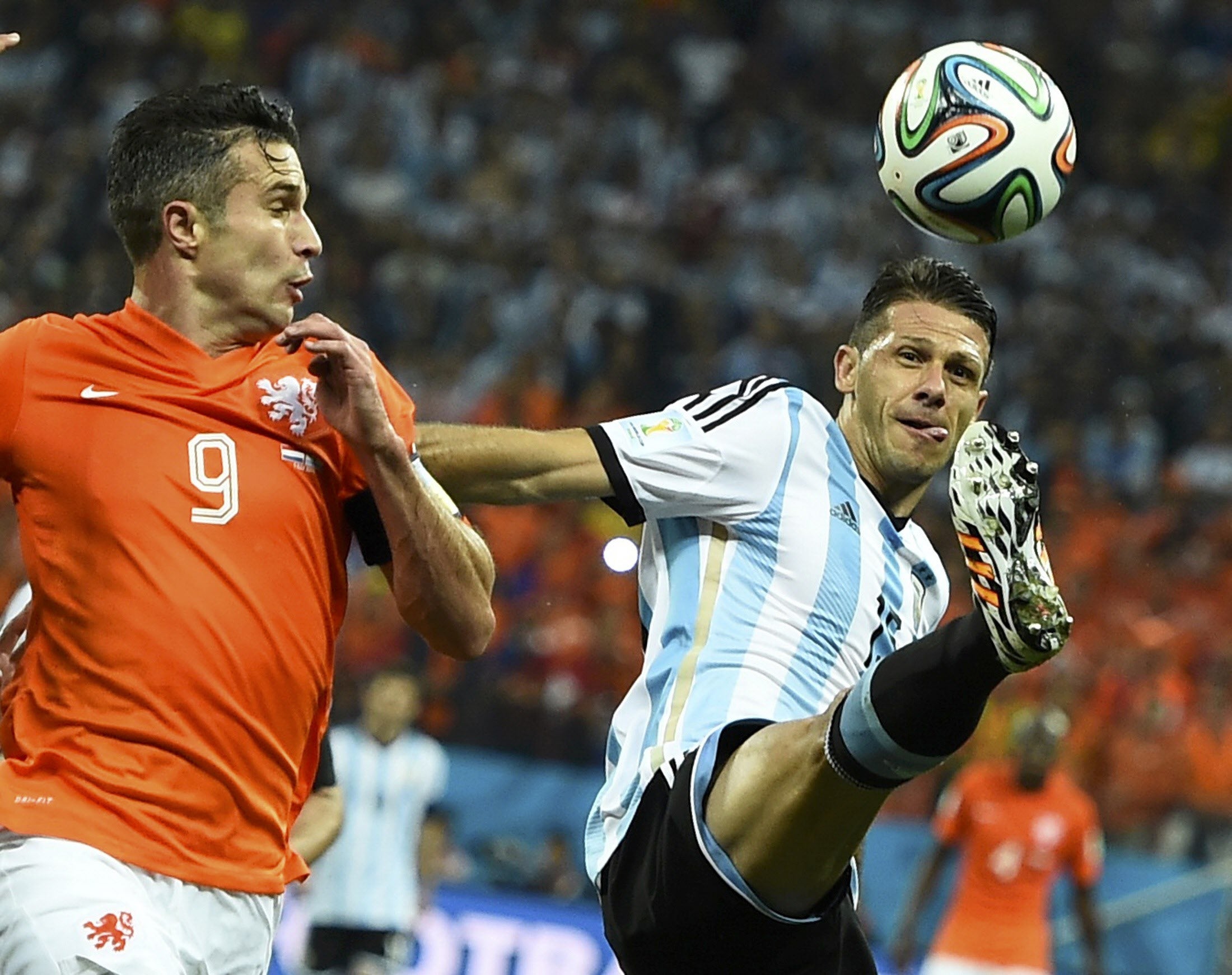 Demichelis (d) controla un balón ante la presión de Van Persie.