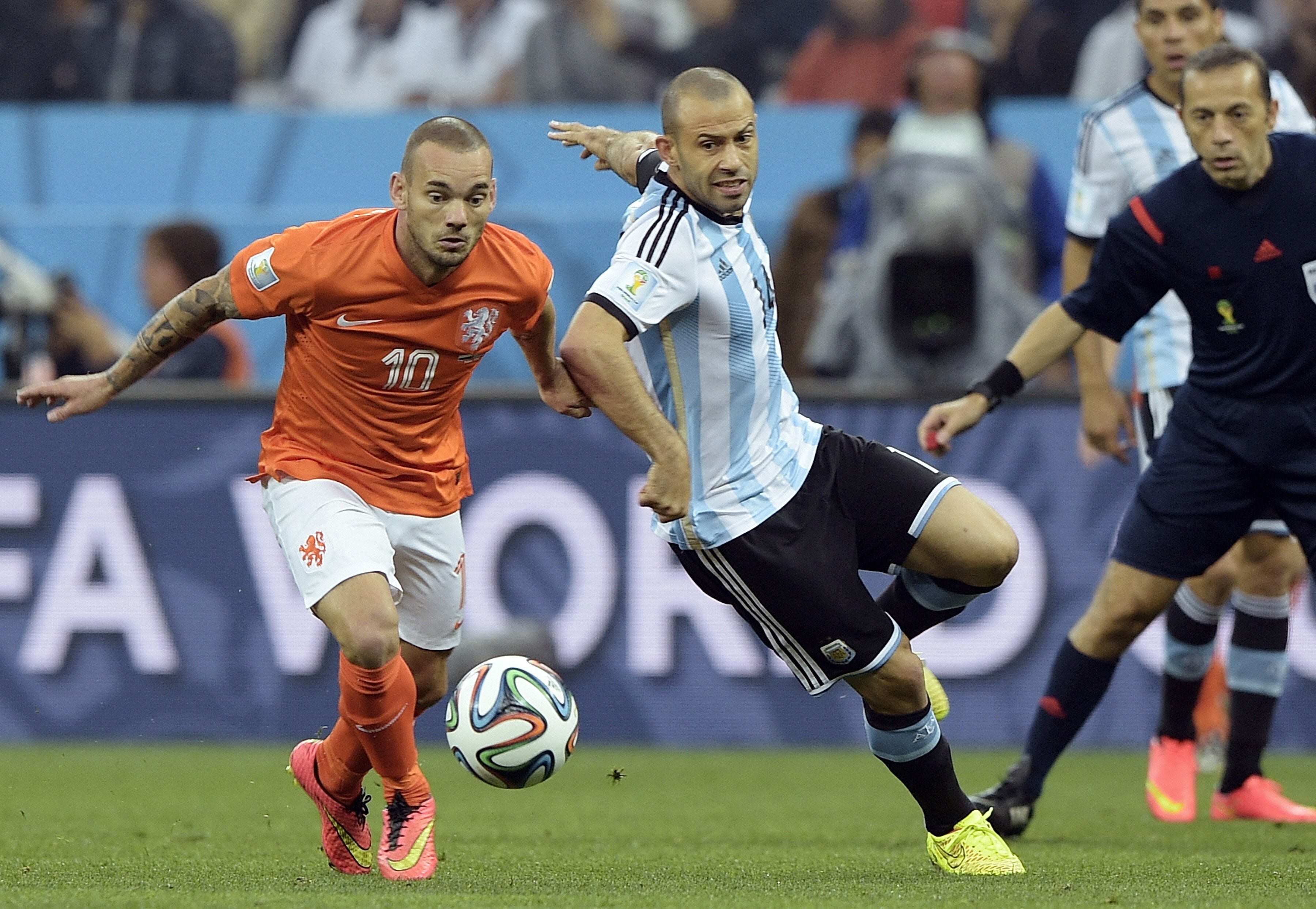 Wesley Sneijder (i) pelea un balón con el argentino Javier Mascherano.