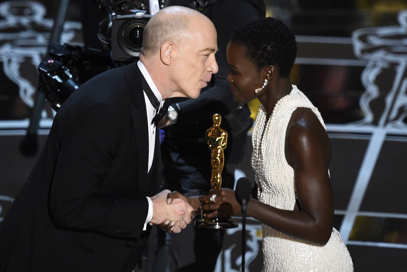 J. K. Simmons recoge el Oscar al mejor actor de reparto, por 'Whiplash', de manos de Lupita Nyong'o.