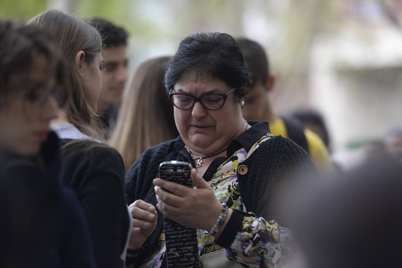 Una mujer llora mientras mira su móvil en el lugar de los hechos.