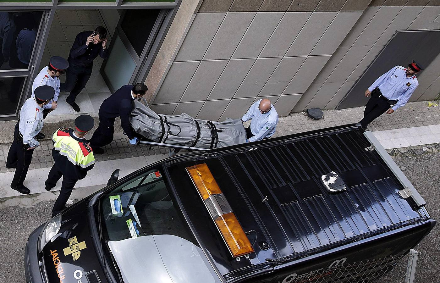 Miembros de los servicios funerarios de Barcelona y del juzgado de guardia retiran el cadáver del profesor fallecido.