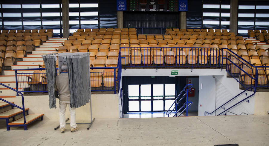 n hombre elige la papeleta el colegio electoral habiltado en el polideportivo Mendizorrotza de Vitoria.