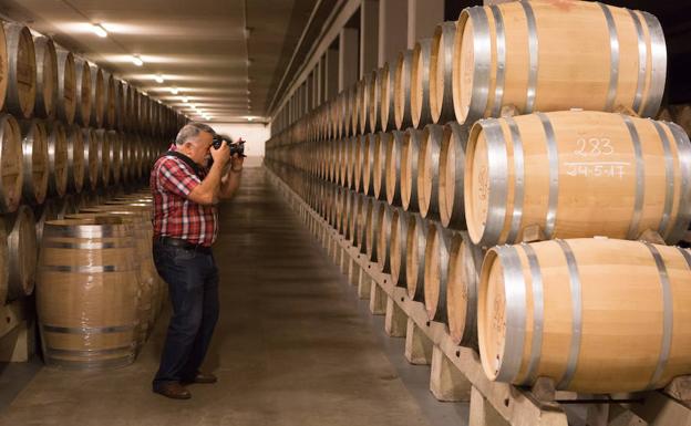 Imagen. Un fotógrafo busca el mejor encuadre en una sala de envejecimiento de La Rioja Alta en Haro. 