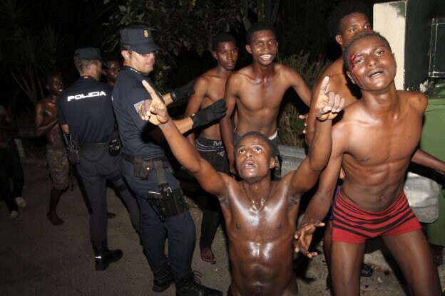 Algunos de los inmigrantes celebran su llegada a Ceuta tras asaltar El Tarajal. :: reduan / EFE