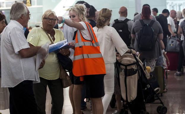 Personal de AENA informa a los usuarios en los accesos a las puertas de embarque del aeropuerto del Prat