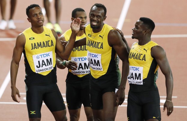 Usain Bolt, consolado por sus compañeros tras su lesión en los Mundiales de Londres. :: afp