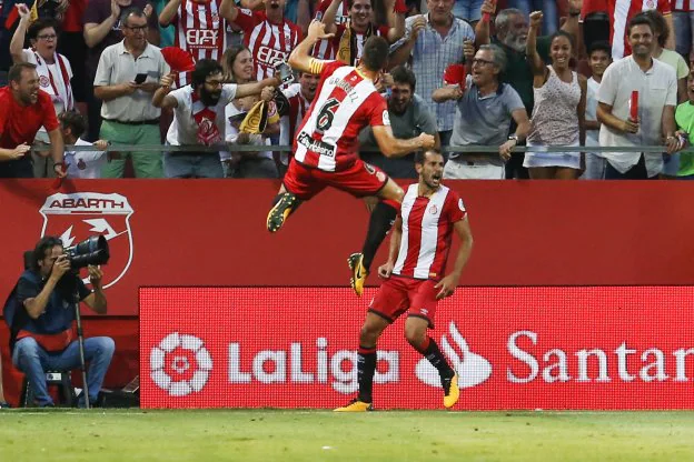 Alex Granell salta de alegría para celebrar el gol de Cristian Stuani, con cara de rabia, que adelantó al Girona ante el Atlético de Madrid. :: afp