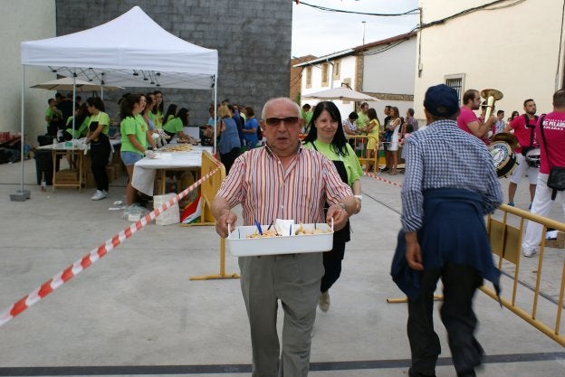 Un asistente se dirige a dar cuenta de una notable ración de cazuelitas de patatas bravas. 