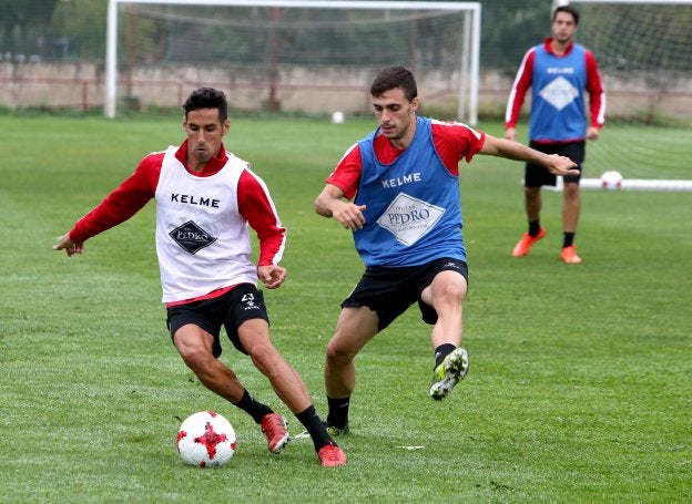 Rayco protege el balón ante el acoso de Arnedo. :: 