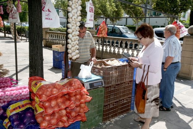 Un par de clientes hacen la compra en uno de los puestos del mercado. :: juan marín