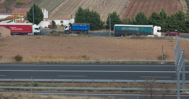 Camiones circulando por la N-232, en el término municipal de Agoncillo, con la autopista en primer plano. :: sonia tercero