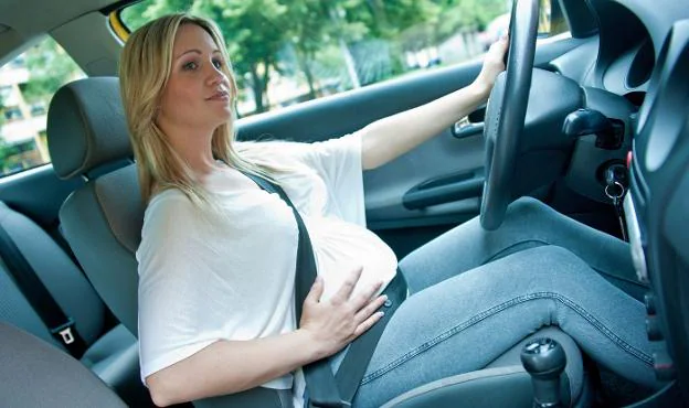 Al volante. Una mujer embarazada conduce un vehículo mientras se toca el vientre. :: L.R.m.