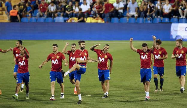 Los jugadores de España, con Gerard Piqué al frente, se ejercitan sobre el césped del Rico Pérez. :: efe