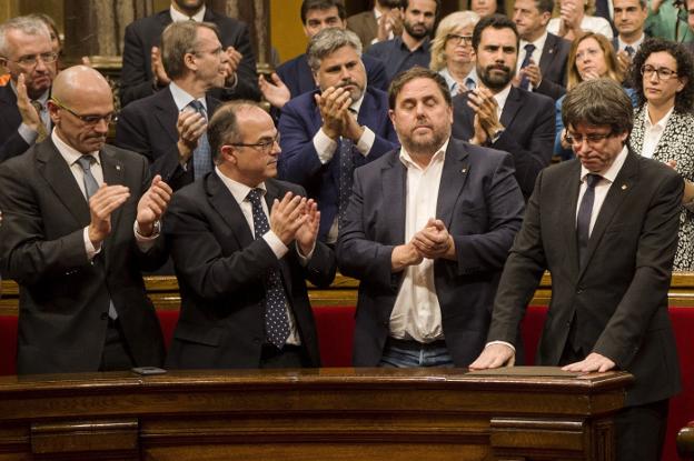 Puigdemont recibe ayer el aplauso de los miembros del Gobierno catalán tras su comparecencia en el Parlament. :: q. dacosta/ efe
