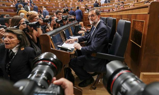Rajoy aguarda sentado en su escaño y rodeado de fotógrafos a que comience el pleno del Congreso sobre Cataluña. :: Sergio Perez / reuters
