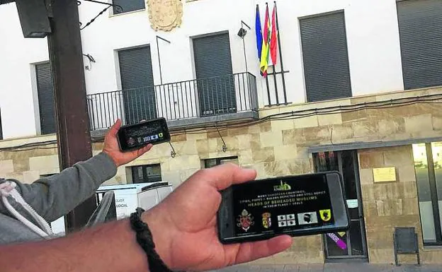 Móviles con la imagen transmitida a través de Telegram de la cuenta de Did you know? frente al Ayuntamiento de Alcanadre. 