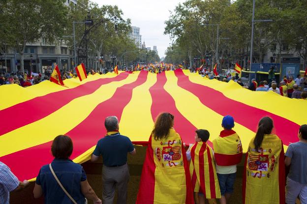 Participantes en la manifestación de Barcelona despliegan una 'senyera'. Abajo, incidentes entre los grupos ultras. :: efe / reuters
