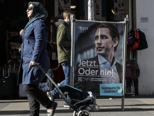 Cartel de campaña con el rostro de Sebastian Kurz, el candidato popular, en una acera en Viena. :: VALDRIN XHEMAJ/ efe
