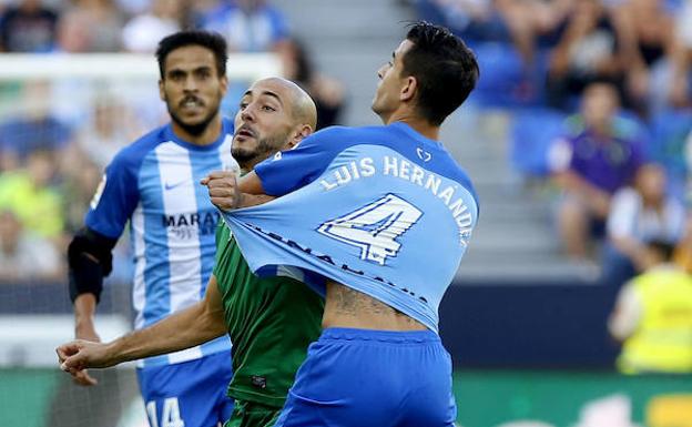 Nordin Amrabat disputando un balón con Luis Hernández.