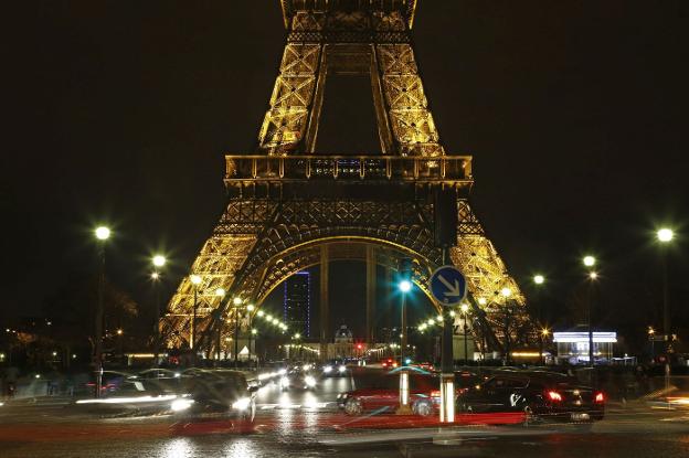 Varios vehículos circulan por debajo de la Torre Eiffel en París, en horario nocturno. :: L.R.M.