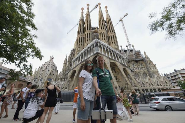 Varios turistas se fotografían junto a la Sagrada Familia en Barcelona. :: LLUIS GENE / afp