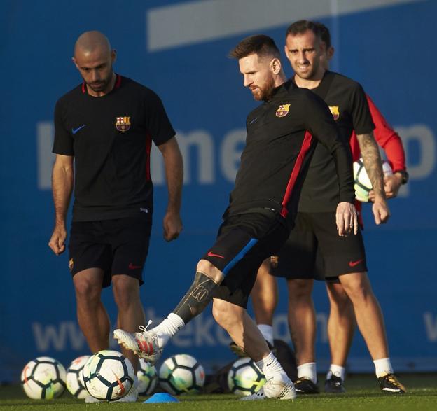 Messi juega con el balón ante la mirada de Mascherano y Alcácer. :: efe
