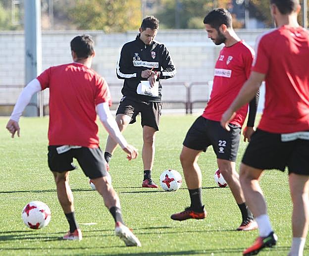 Sergio Rodríguez consulta sus papeles en el entrenamiento, mientras Rayco conduce el balón.