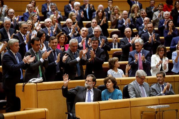 Rajoy saluda a los senadores del PP tras exponer el plan de intervención de la Generalitat. :: Chema Moya/ efe
