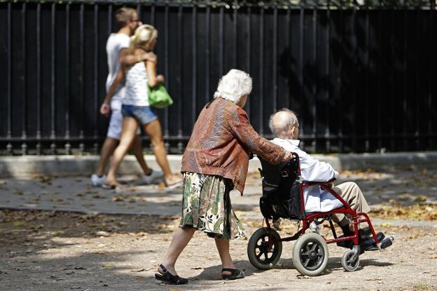 Dos jubilados pasean por la calle al lado de una pareja de jóvenes.:: reuters