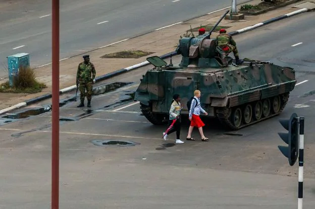 Dos mujeres pasan junto a un tanque desplegado ayer en las calles de Harare, capital de Zimbabue. :: Jekesai NJIKIZANA / afp