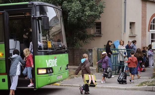 Niños acuden a la escuela en un transporte escolar. 