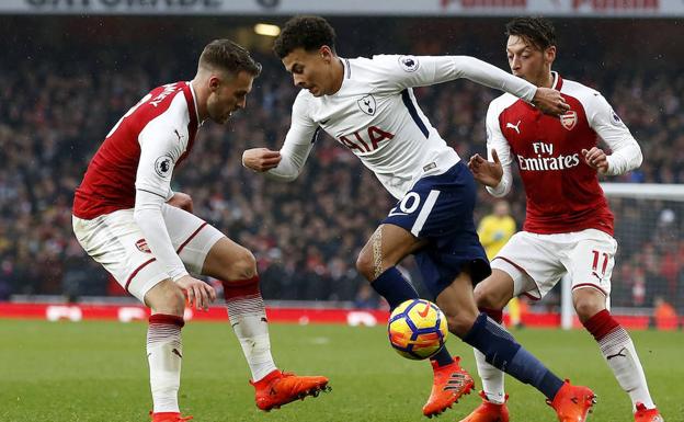 Dele Alli encara a dos jugadores del Arsenal.