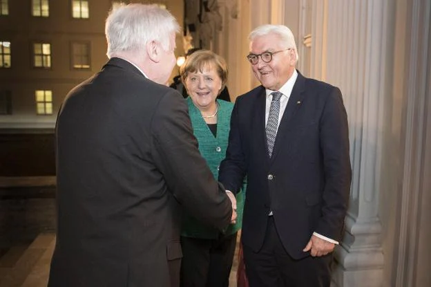 Horst Seehofer, saluda la presidente alemán, Frank-Walter Steinmeier, con Merkel al fondo. :: g. B. / efe